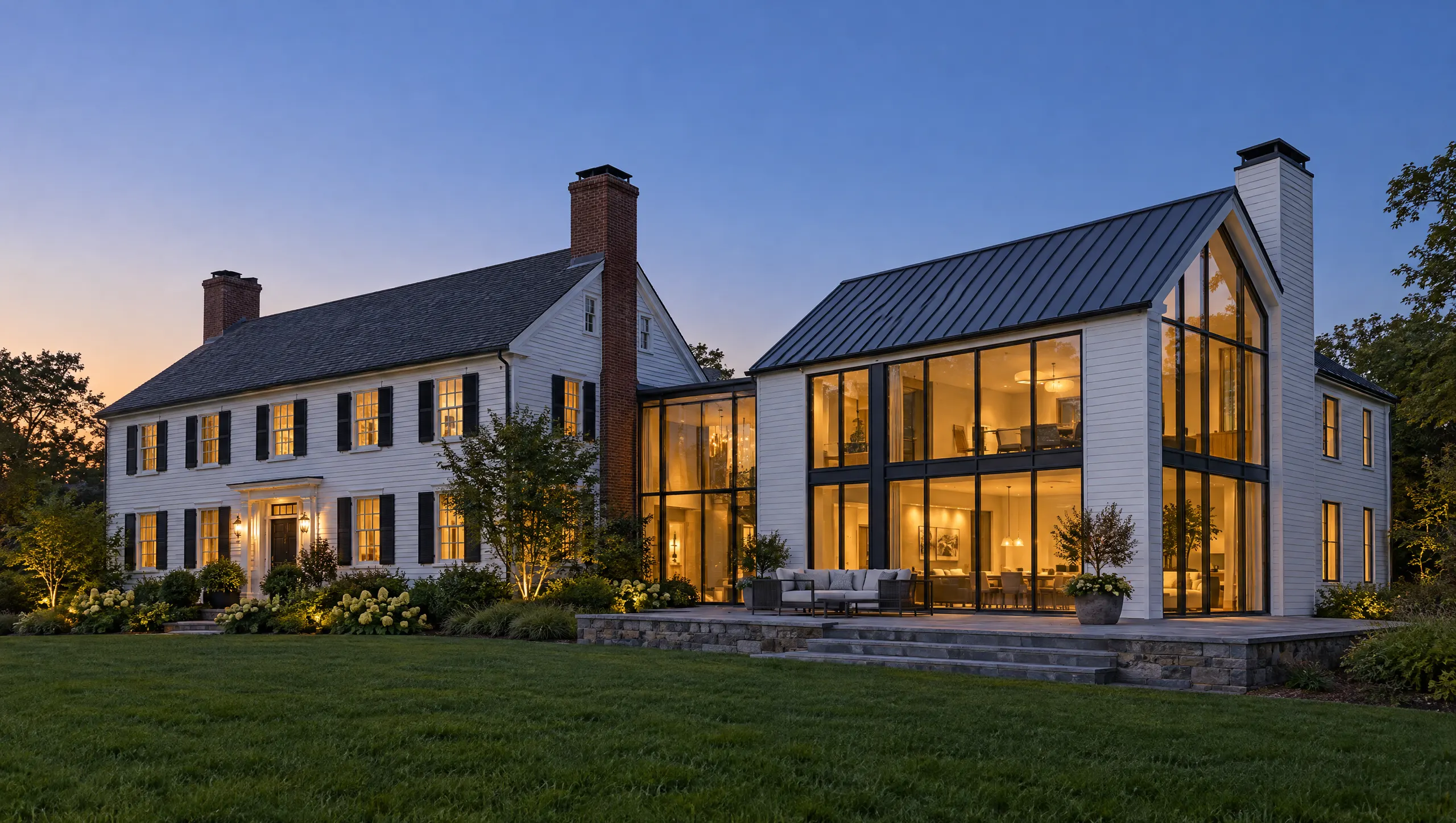 New steel-and-glass wing joined to a white clapboard colonial at twilight